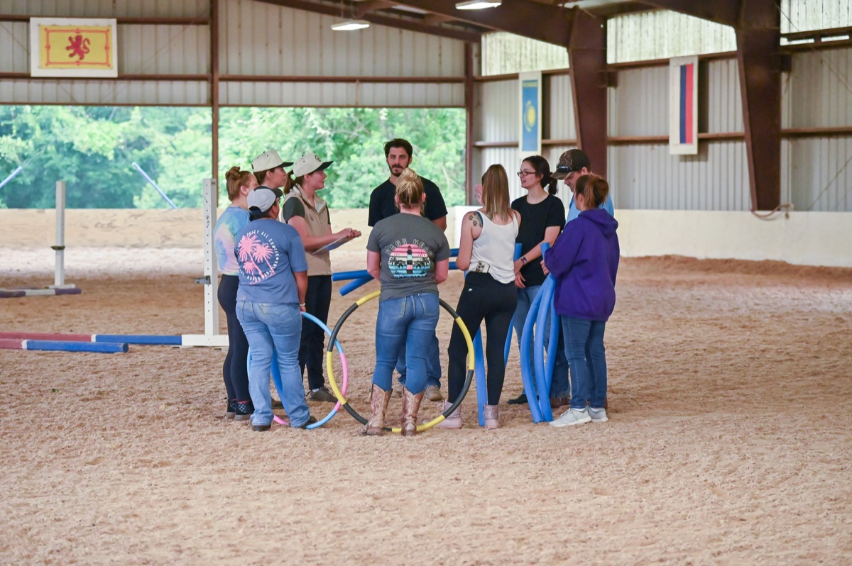 A team working through an activity together in the covered arena